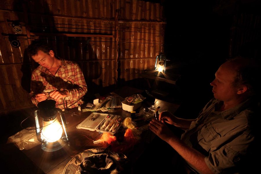 Rob_Scott_and_Ed_Truter_tying_flies_at_lamplight_in_Tengo_Camp